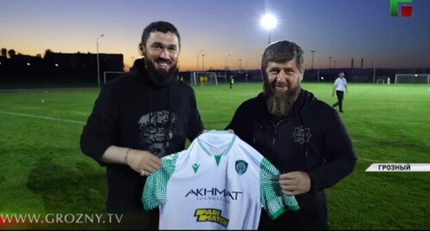 Magomed Daudov presents Ramzan Kadyrov with a T-shirt of the Akhmat football club with the emblem of a bookmaker, July 31, 2021. Screenshot: http://www.youtube.com/watch?v=uLU3QA4zGuE&t=525s Magomed Daudov presents Ramzan Kadyrov with a T-shirt of the Akhmat football club with the emblem of a bookmaker, July 31, 2021. Screenshot: http://www.youtube.com/watch?v=uLU3QA4zGuE&t=525s