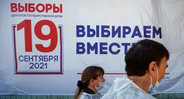 Members of local electoral commission walk past the electoral board on the first day of three-day parliamentary elections in Russia, September 17, 2021. Photo: REUTERS/Maxim Shemetov Members of local electoral commission walk past the electoral board on the first day of three-day parliamentary elections in Russia, September 17, 2021. Photo: REUTERS/Maxim Shemetov