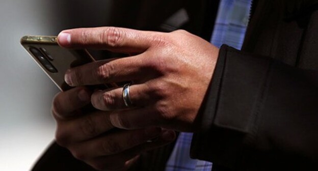 A man holding a smartphone. Photo: REUTERS/Эдгард Гарридо A man holding a smartphone. Photo: REUTERS/Эдгард Гарридо
