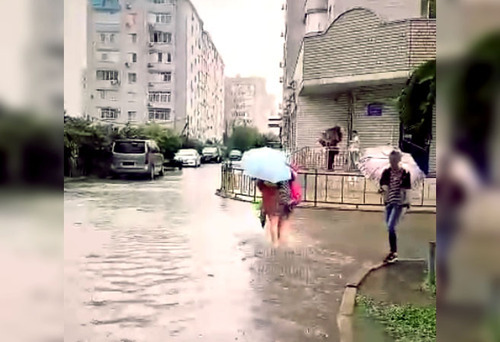 A resident of Krasnodar walks along a flooded street. Image made from video posted at: https://vk.com/wall-33025155_10315557 A resident of Krasnodar walks along a flooded street. Image made from video posted at: https://vk.com/wall-33025155_10315557