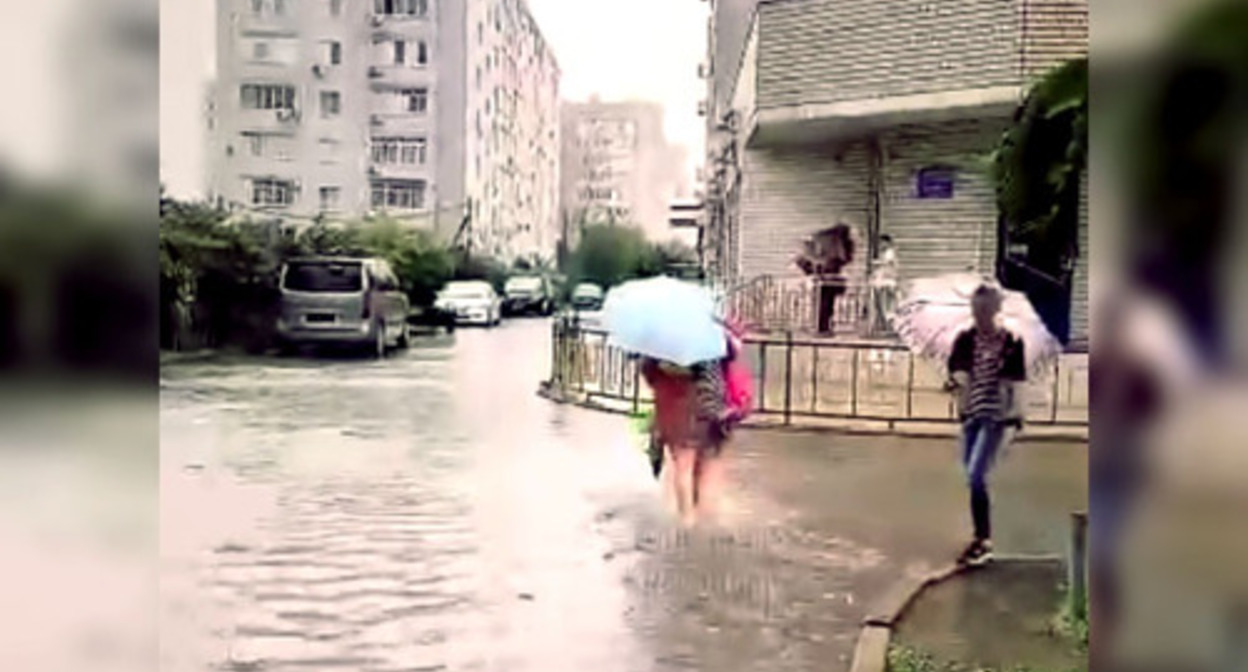 A resident of Krasnodar walks along a flooded street. Image made from video posted at: https://vk.com/wall-33025155_10315557 A resident of Krasnodar walks along a flooded street. Image made from video posted at: https://vk.com/wall-33025155_10315557