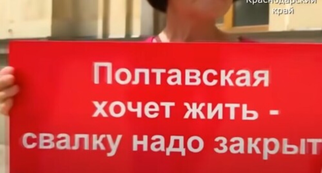 A protester against the garbage landfill located in the village of Poltavskaya holding a banner. Screenshot of the video https://www.youtube.com/watch?v=y7Emul88e0k A protester against the garbage landfill located in the village of Poltavskaya holding a banner. Screenshot of the video https://www.youtube.com/watch?v=y7Emul88e0k