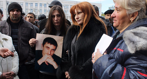 Vladimir Tskaev's relatives holding his photo near the building of the Government of North Ossetia–Alania. Photo: https://twitter.com Vladimir Tskaev's relatives holding his photo near the building of the Government of North Ossetia–Alania. Photo: https://twitter.com