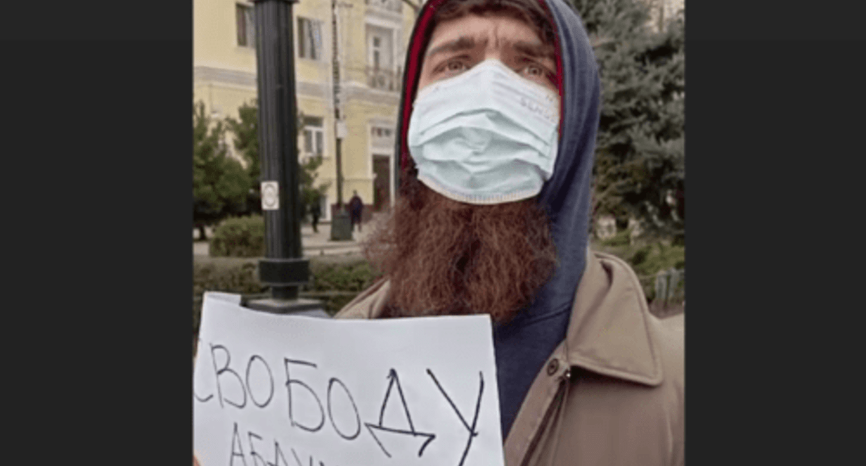 A man unfolded a poster next to Idris Yusupov* (included into the register of foreign agents), who was holding a solo picket, so the journalist had to stop his protest action. Screenshot of a video posted on the Telegram channel of the newspaper “Chernovik” (Rough Draft) on January 29, 2024 https://t.me/chernovik/67013 A man unfolded a poster next to Idris Yusupov* (included into the register of foreign agents), who was holding a solo picket, so the journalist had to stop his protest action. Screenshot of a video posted on the Telegram channel of the newspaper “Chernovik” (Rough Draft) on January 29, 2024 https://t.me/chernovik/67013