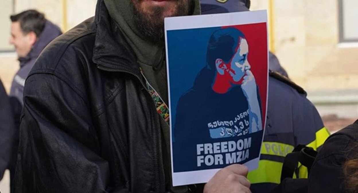 An activist holds a poster with the photo of Mziya Amaglobeli. Tbilisi, January 20, 2025. Photo: Publika https://t.me/Tbilisi_life An activist holds a poster with the photo of Mziya Amaglobeli. Tbilisi, January 20, 2025. Photo: Publika https://t.me/Tbilisi_life