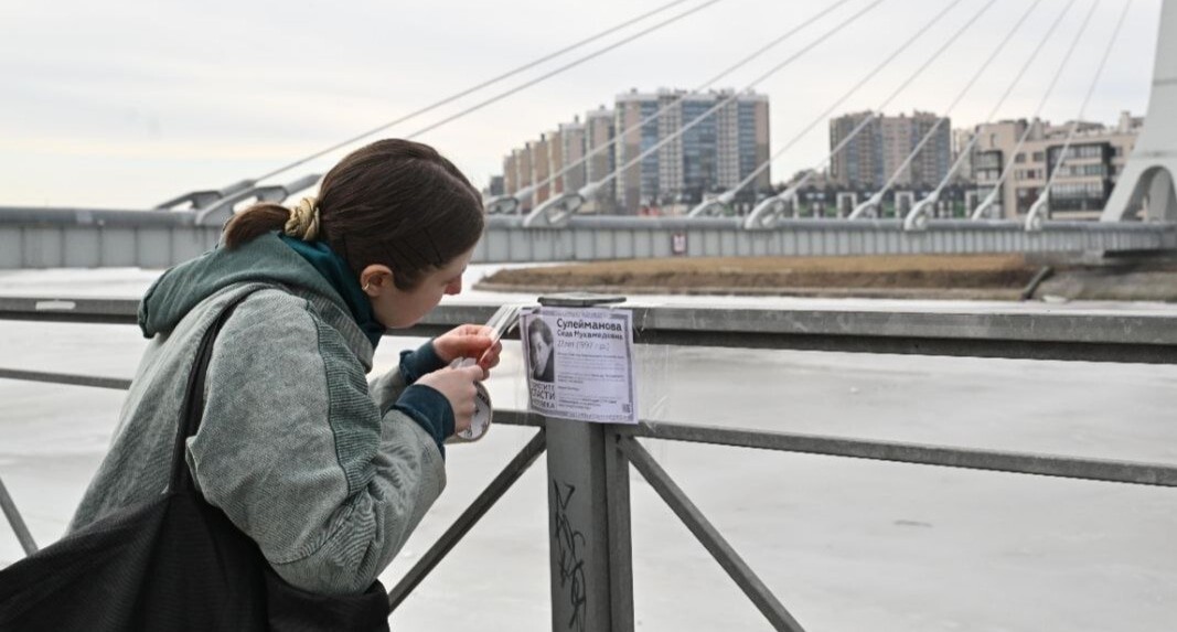Elena Patyaeva sticks a leaflet on the bridge railing. St. Petersburg, March 8, 2025. Photo posted on Elena Patyaeva's Telegram channel https://t.me/helpseda/313