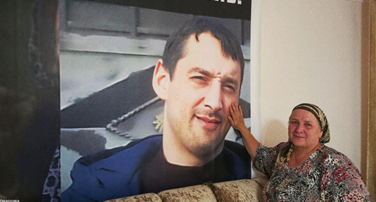 Eset Umarova next to a portrait of her son Movsar: photo: https://t.me/no_torture/3635. Eset Umarova next to a portrait of her son Movsar: photo: https://t.me/no_torture/3635.