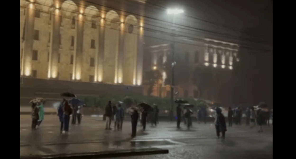 Activists under umbrellas near the Georgian parliament. Still frame from Lorena Beria's video? https://t.me/Tbilisi_life/41897