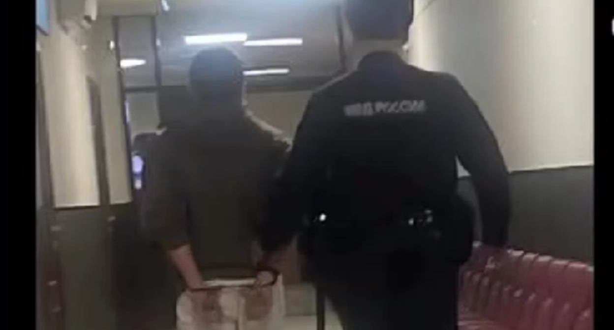 Roman Murdiev is led down an empty courtroom corridor. A still from a video in the possession of the "Caucasian Knot."