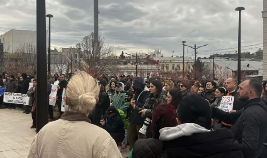 Protesters in Tbilisi. Screenshot from Interpressnews, March 28, 2026, https://www.interpressnews.ge/ka/article/865742-mtavrobis-administraciastan-diushenit-daavadebuli-bavshvebis-mxardamcheri-akcia-gaimarta