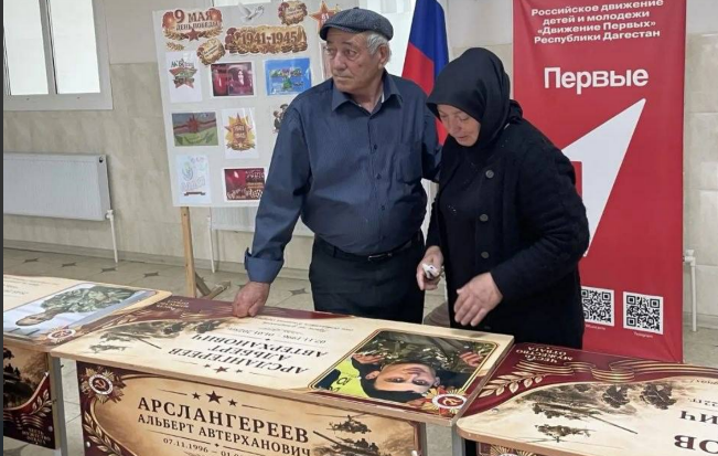 Relatives at the unveiling of a personalized desk. Screenshot from the Babayurt District Administration, May 25, 2026, https://t.me/babayurtrayon/12221?single Relatives at the unveiling of a personalized desk. Screenshot from the Babayurt District Administration, May 25, 2026, https://t.me/babayurtrayon/12221?single