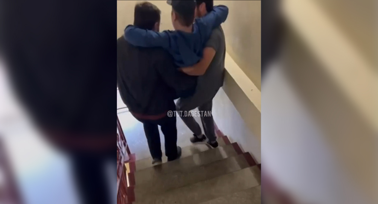 Two men are carrying a patient down the stairs in a Makhachkala hospital. Frame from the video https://www.instagram.com/tut.dagestan/reel/Dc_gyg2qE_z (the activities of Meta (owner of Facebook, Instagram, and WhatsApp) are banned in Russia)